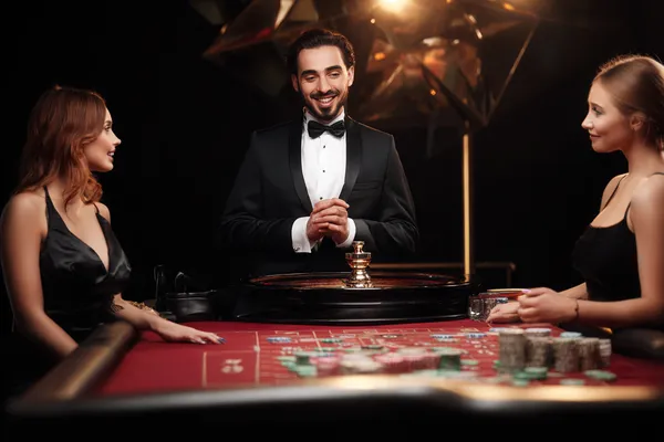 A woman in a luxurious green gown next to an ornate roulette wheel, capturing the upscale casino mood of BA999A.